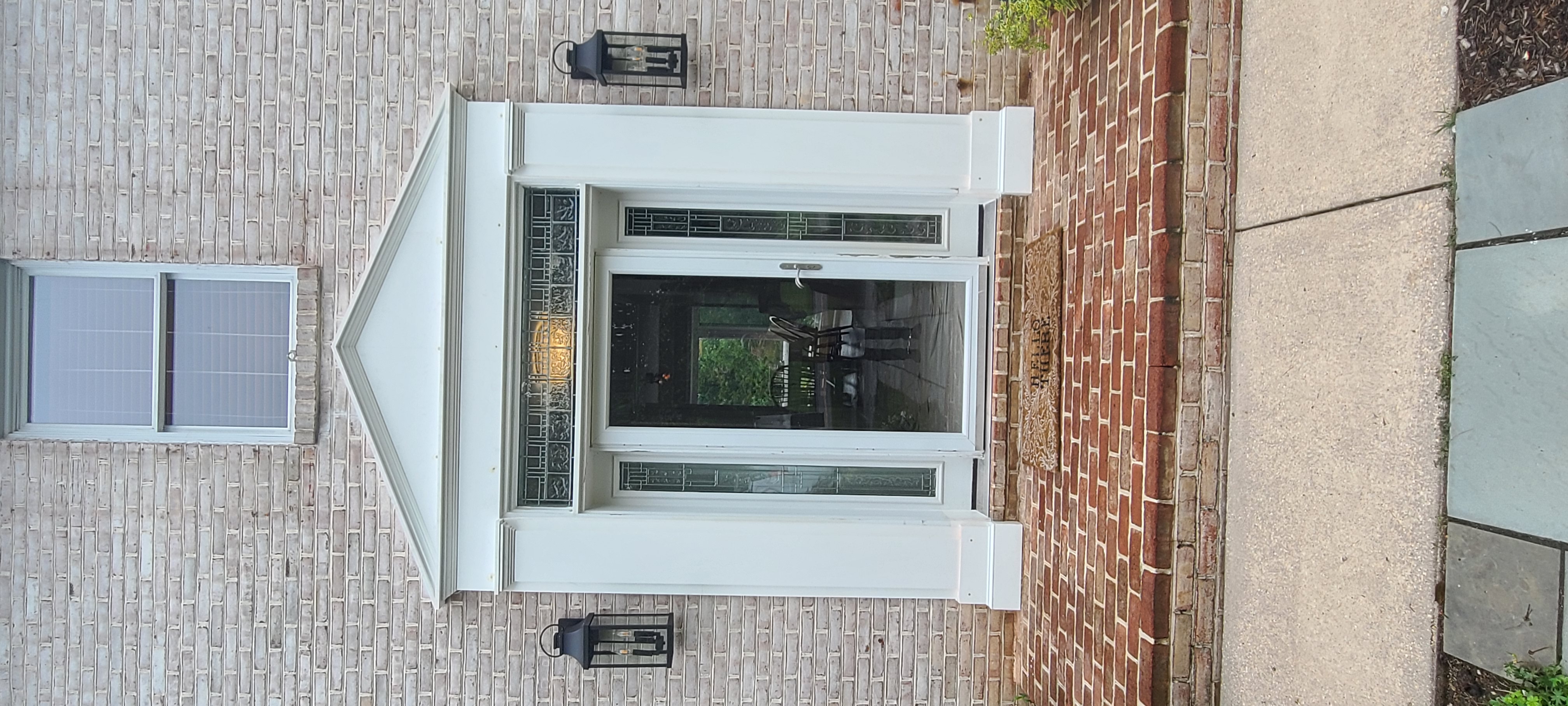 A residential entry portico with peaked pediment, sidelights, transom, and traditional white-painted millwork